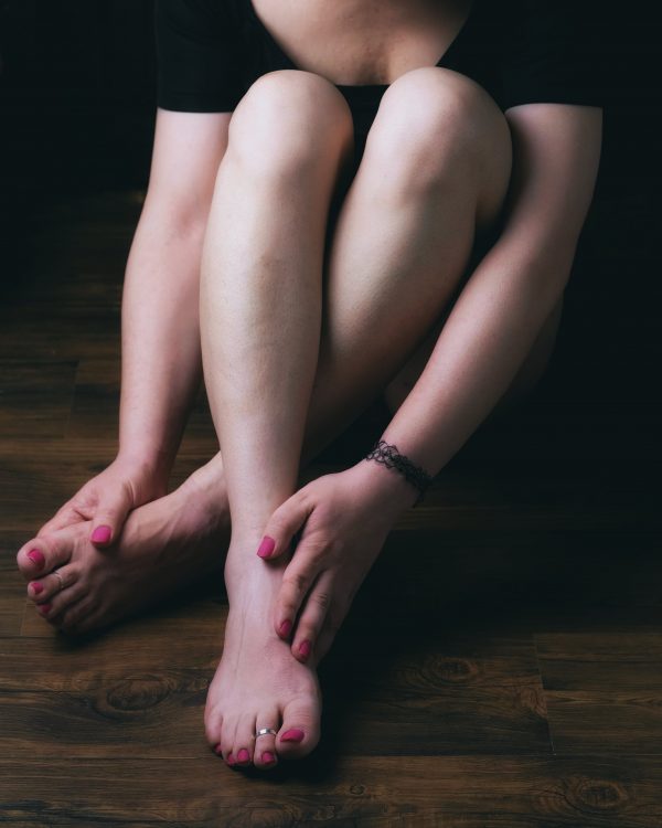 woman touching her legs and feet